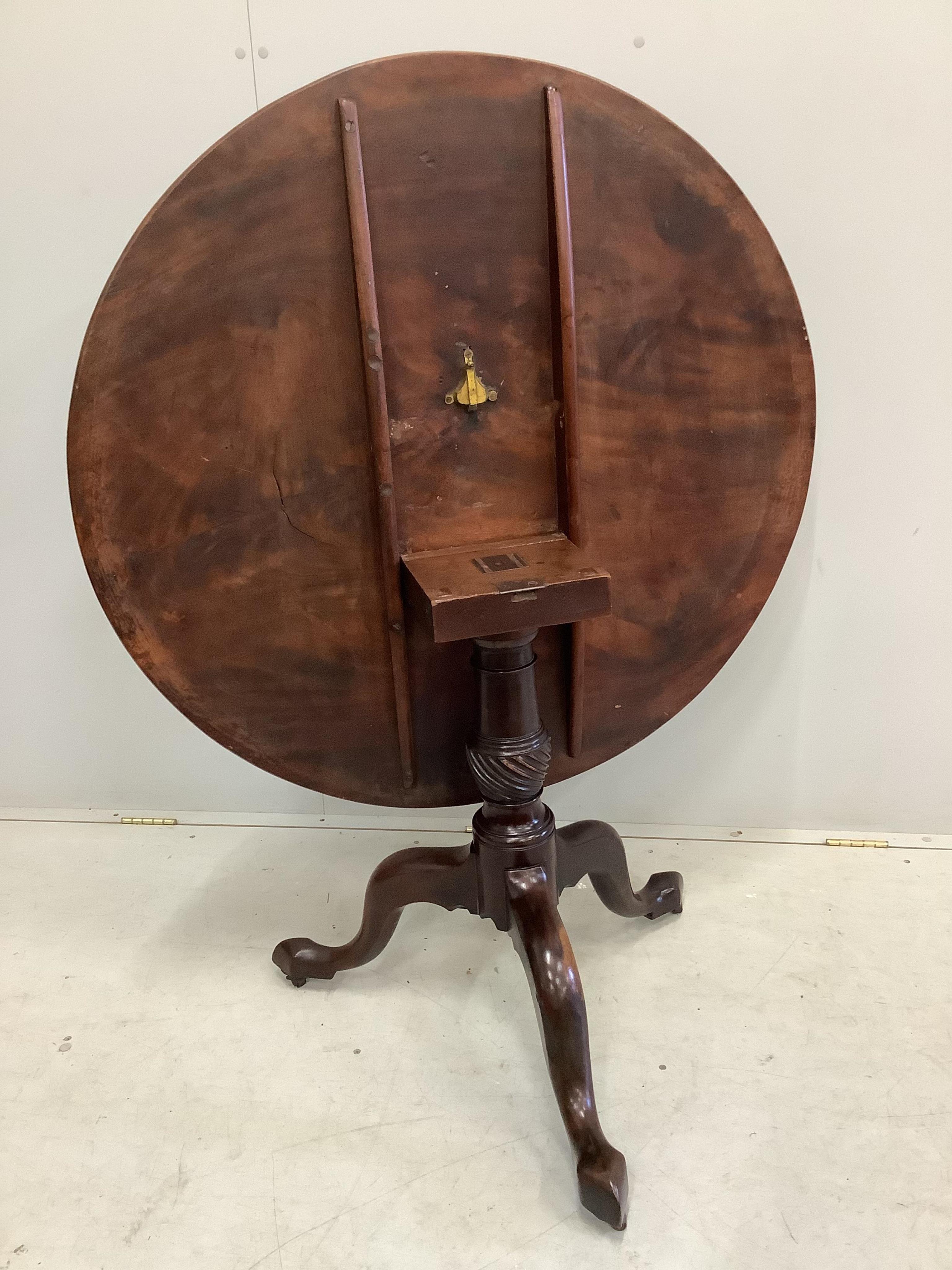 A George III circular mahogany tilt top tripod tea table, diameter 99cm, height 75cm together with four George III mahogany dining chairs. Condition - fair